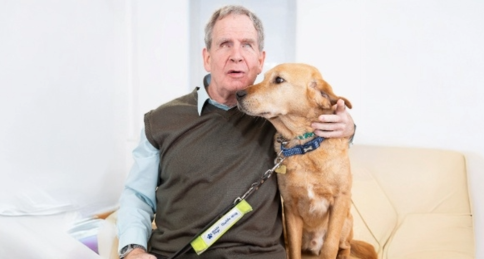 BWBF Chair of Trustees Mike Brace with one arm around his guide dog.