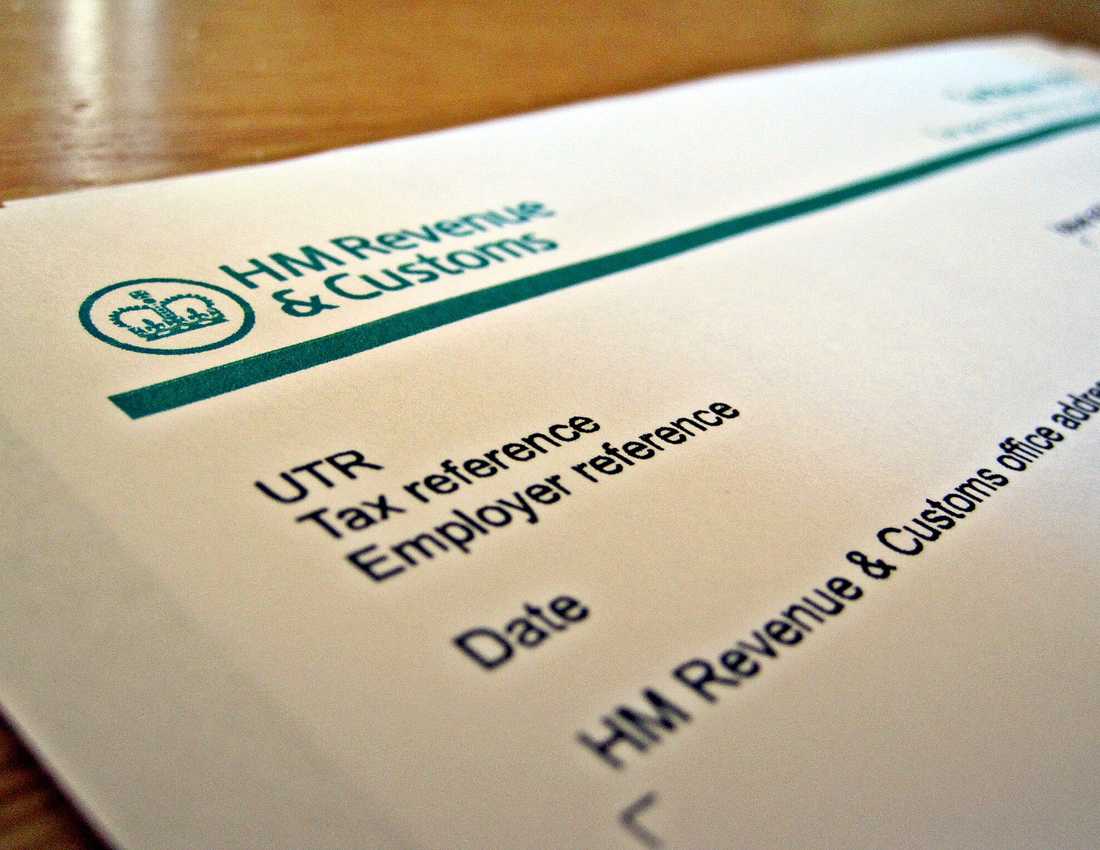 An image of a tax return form. Text at the top reads HM Revenue & Customs. A pen lies on top of the form.